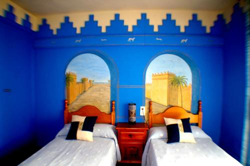 - 2 lits dans une chambre aux murs bleus dans l'établissement Pensión El Alamo, à Lepe