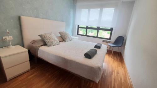 um quarto com uma cama com duas almofadas em ZUBEROA- vistas, terraza y parking em Zarautz