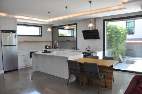 a kitchen with a large island with a wooden table at Villa Elite in Kusadası