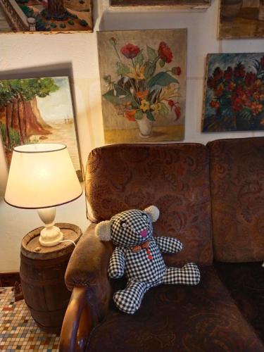 a teddy bear sitting on a couch next to a lamp at Le jardin Renard-Clos sur Loir cottage in the Loir & Loire valleys in La Chapelle-aux-Choux
