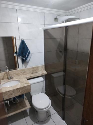 uma casa de banho com um WC, um chuveiro e um lavatório. em Casa Térrea Oliveira inteira em São José dos Pinhais