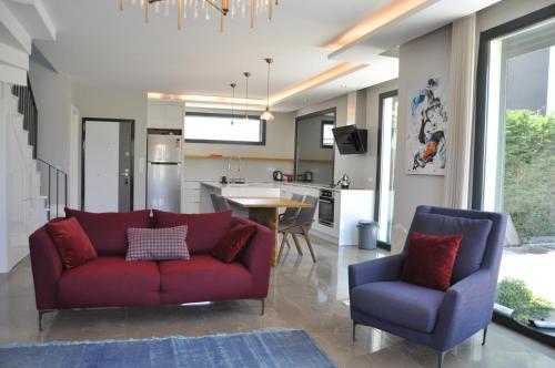 a living room with a red couch and two chairs at Villa Elite in Kusadası