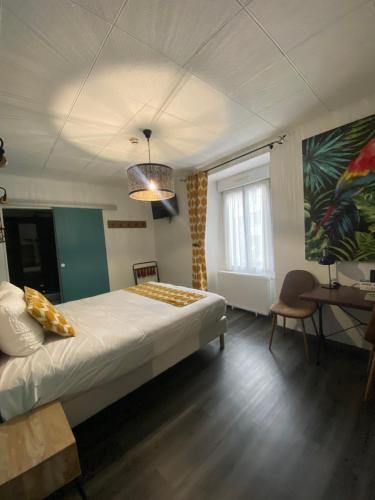 1 dormitorio con cama, mesa y ventana en Logis Central Hôtel & Spa, en Bort-les-Orgues