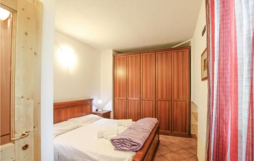 a small bedroom with a bed and a wooden cabinet at Amazing Apartment In Mezzana With Wifi in Mezzana