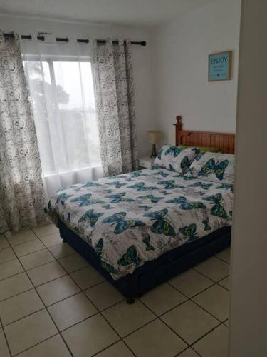 a bedroom with a bed and a window at Laguna La Crete-Uvongo in Margate