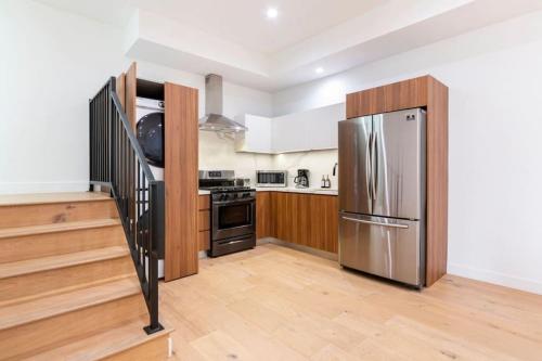 a kitchen with a stainless steel refrigerator and a staircase at Brand NEW Luxury 2bd Townhouse Pet-Friendly FREE Parking in Los Angeles