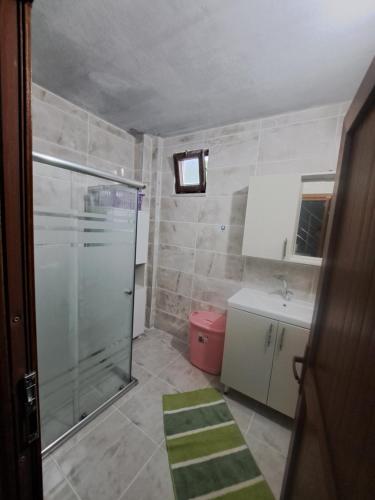 a small bathroom with a shower and a sink at Yılmaz Villa in Macka