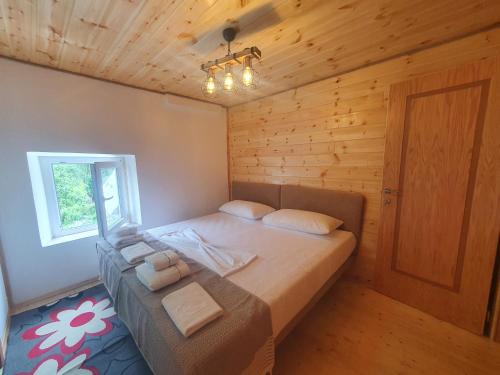 ein Schlafzimmer mit einem großen Bett in einem Holzzimmer in der Unterkunft Villa Davisol in Theth