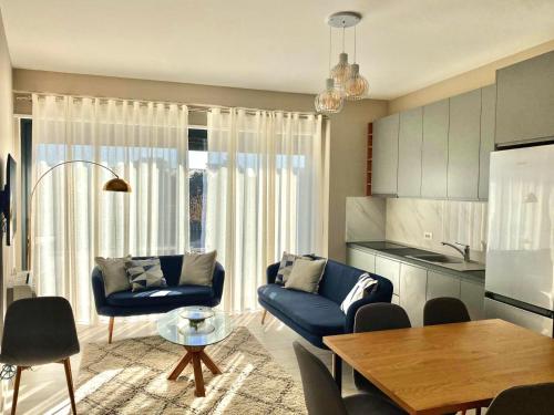 - un salon avec un canapé bleu et une table dans l'établissement Alma Rose Apartment, à Korçë