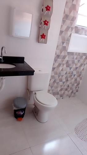 a bathroom with a toilet and a sink at Casa de praia Melo in Itanhaém