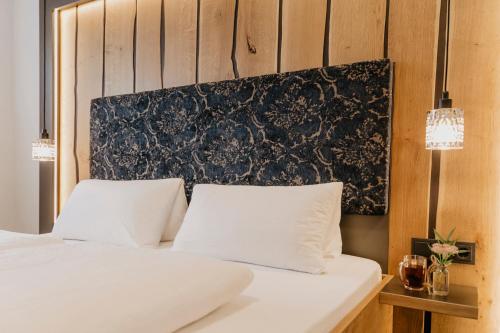 a bedroom with two white beds and a black headboard at Weßner Hof Landhotel & Restaurant in Marquartstein