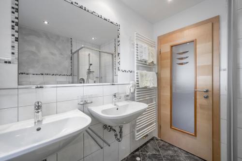 ein weißes Badezimmer mit 2 Waschbecken und einem Spiegel in der Unterkunft Ferienhaus Platöll in Serfaus