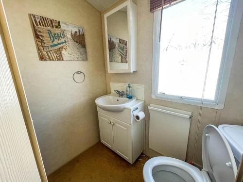 y baño con lavabo y aseo. en Brilliant Caravan With Decking And Wifi At Dovercourt Park In Essex Ref 44010a, en Great Oakley