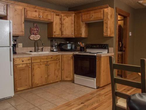 une cuisine avec des armoires en bois et un réfrigérateur blanc dans l'établissement Sorrel River Ranch Resort and Spa, à Castle Valley