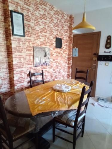 jadalnia ze stołem i żółtym kocem w obiekcie Appartement calme au centre w mieście Wadżda