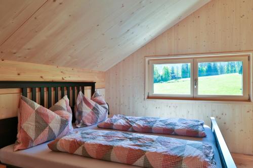 ein Schlafzimmer mit einem Bett und einem Fenster in einem Zimmer in der Unterkunft Bergreich Appartement 5 in Schoppernau