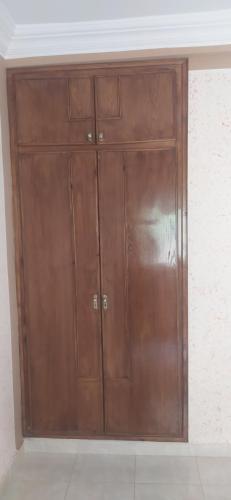 un placard en bois avec deux portes dans une chambre dans l'établissement مدينه صفرو المغرب, à Séfrou