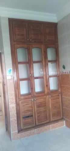a wooden cabinet with glass doors in a room at مدينه صفرو المغرب in Sefrou