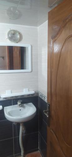 a bathroom with a sink and a mirror and a door at مدينه صفرو المغرب in Sefrou