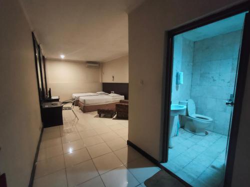 a room with a bathroom with a bed and a toilet at Hotel Syariah Taman Cibinong 2 By FPH 