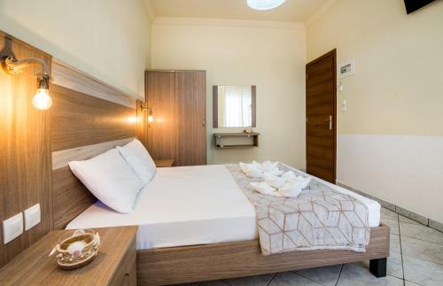 a bedroom with a large bed with a wooden headboard at Ianos Apartments in Potos