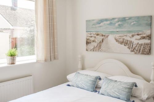 een slaapkamer met een bed en een foto van een strand bij Lovely Bungalow Close to Beach in Prestatyn