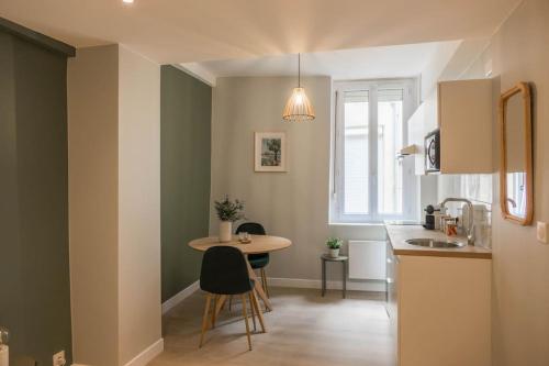 une petite cuisine avec une table et un évier dans l'établissement Bel appartement idéalement situé, à Orléans