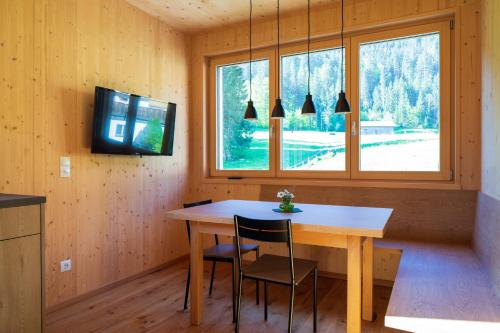 uma sala de jantar com uma mesa de madeira e uma janela em Bergreich Appartement 4 em Schoppernau