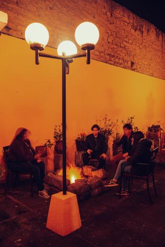 a group of people sitting around a fire in a room at La Posada Colonial in Quito