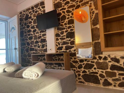 a bedroom with two beds and a rock wall at Eleni B&B in Limánion