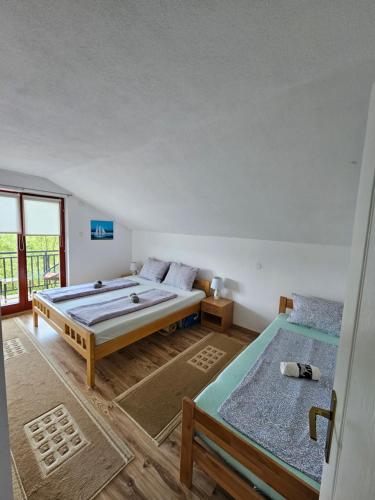 1 dormitorio con 2 camas y ventana en Guest house Al Meri, en Travnik