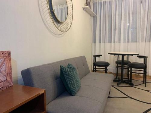 a living room with a couch and a table and a mirror at 807. Departamento entero en Chorrillos in Lima