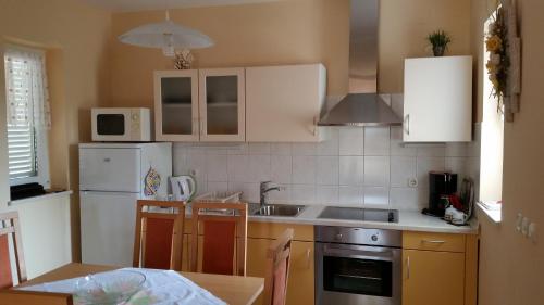 a kitchen with a white refrigerator and a sink at Apartments Kristina in Klenovica