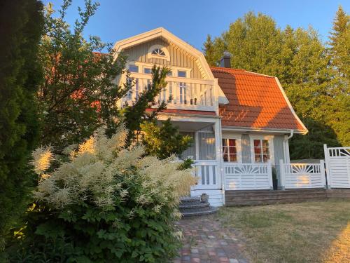 a white house with an orange roof at Family Holiday and Business Home with a Garden in Kallfors, Stockholm near a Golf Course, Lakes, the Baltic Sea, Forests & Nature in Järna