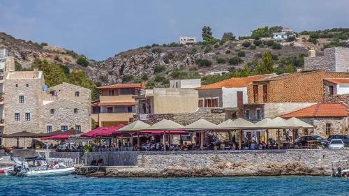 un grupo de personas sentadas en un restaurante junto al agua en Η Αρμενόπετρα, en Yerolimin
