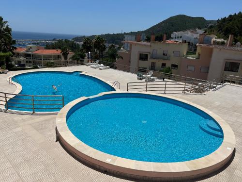 due grandi piscine blu in cima a un edificio di Ocean Drive a Sesimbra