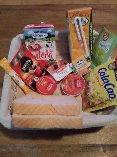 Una cesta de comida con queso y otros bocadillos. en Casa Rural "La Muela de Alarilla", en Alarilla