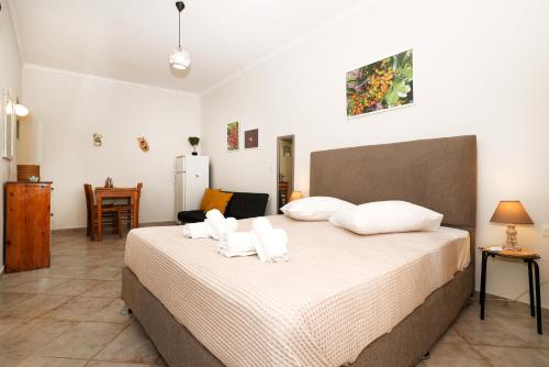 um quarto com uma cama grande e almofadas brancas em Feidiou 1, vol I em Egina