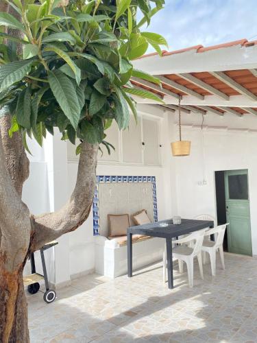 a patio with a table and a tree at Casa da Nespereira in Portimão