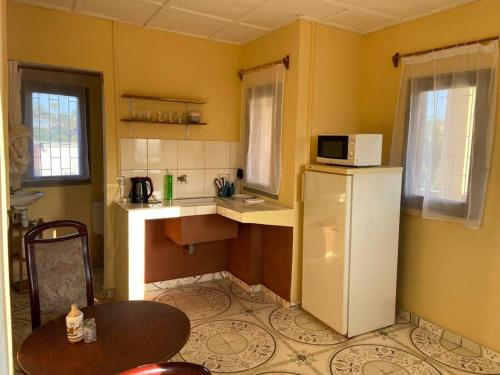 Il comprend une petite cuisine équipée d'un réfrigérateur et d'une table. dans l'établissement Appartement indépendant et équipé, à Fort-Dauphin