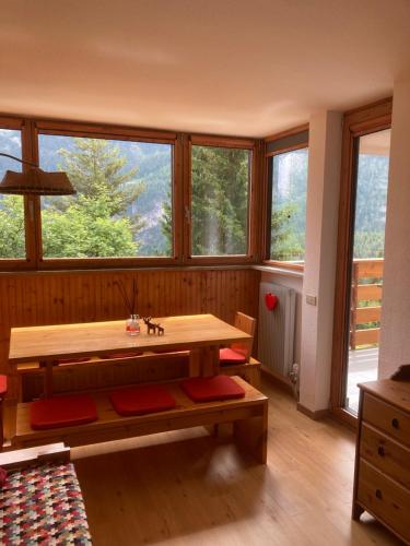 een kamer met een houten tafel en een aantal ramen bij Residence Larici Belvedere in Folgarida
