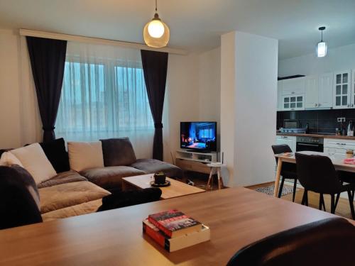 sala de estar con sofá y mesa en Cozy near City Center Apartment! en Pristina