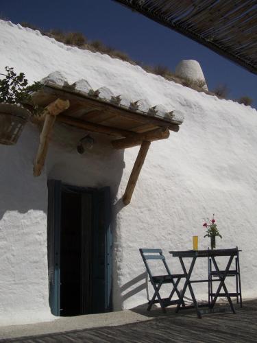 a white building with a table and two chairs at Al Jatib in Baza