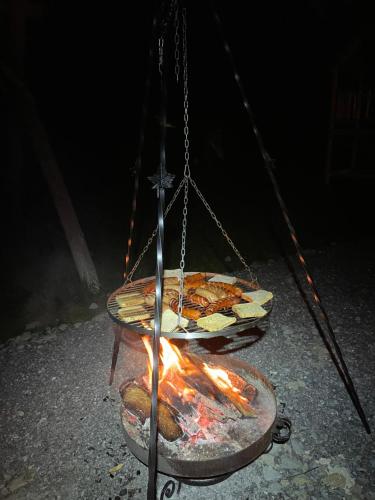 einen hängenden Grill mit Essen und einem Kamin in der Unterkunft Obrochtowa Chata in Kościelisko