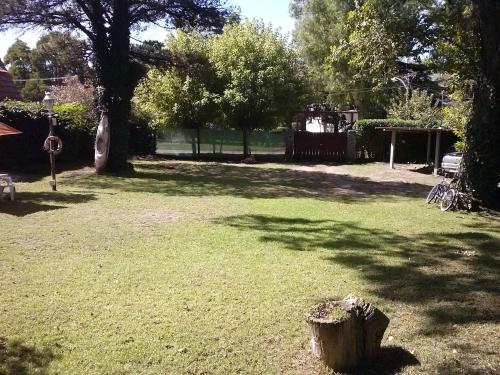 a tree stump in the middle of a grass field at Cabañas Manamar in Villa Gesell