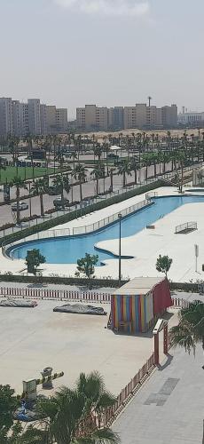 a large swimming pool in a city with buildings at Porto golf marina in El Alamein