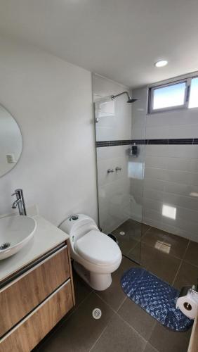 La salle de bains est pourvue de toilettes, d'un lavabo et d'une douche. dans l'établissement Apto zion, à Medellín