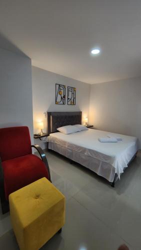 1 dormitorio con 1 cama y 1 silla roja en Apto zion, en Medellín