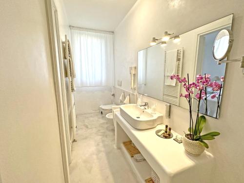 ein weißes Badezimmer mit 2 Waschbecken und einem Spiegel in der Unterkunft Adagio Salentino in Porto Cesareo