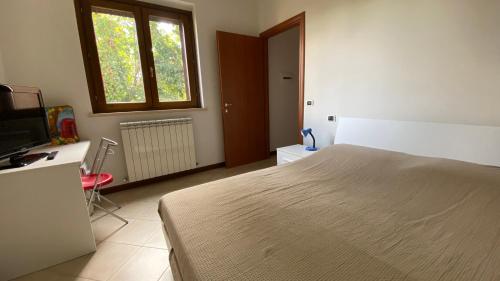 a bedroom with a bed and a desk and a television at La Casa delle Ciliegie in Assisi